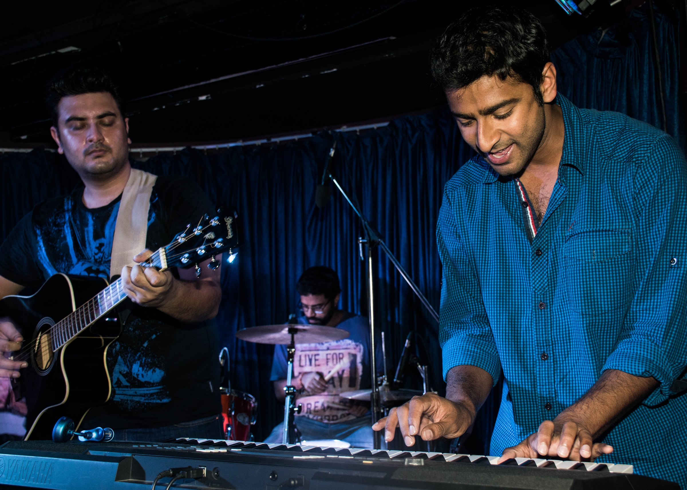 Band on stage with guitar, piano and drums