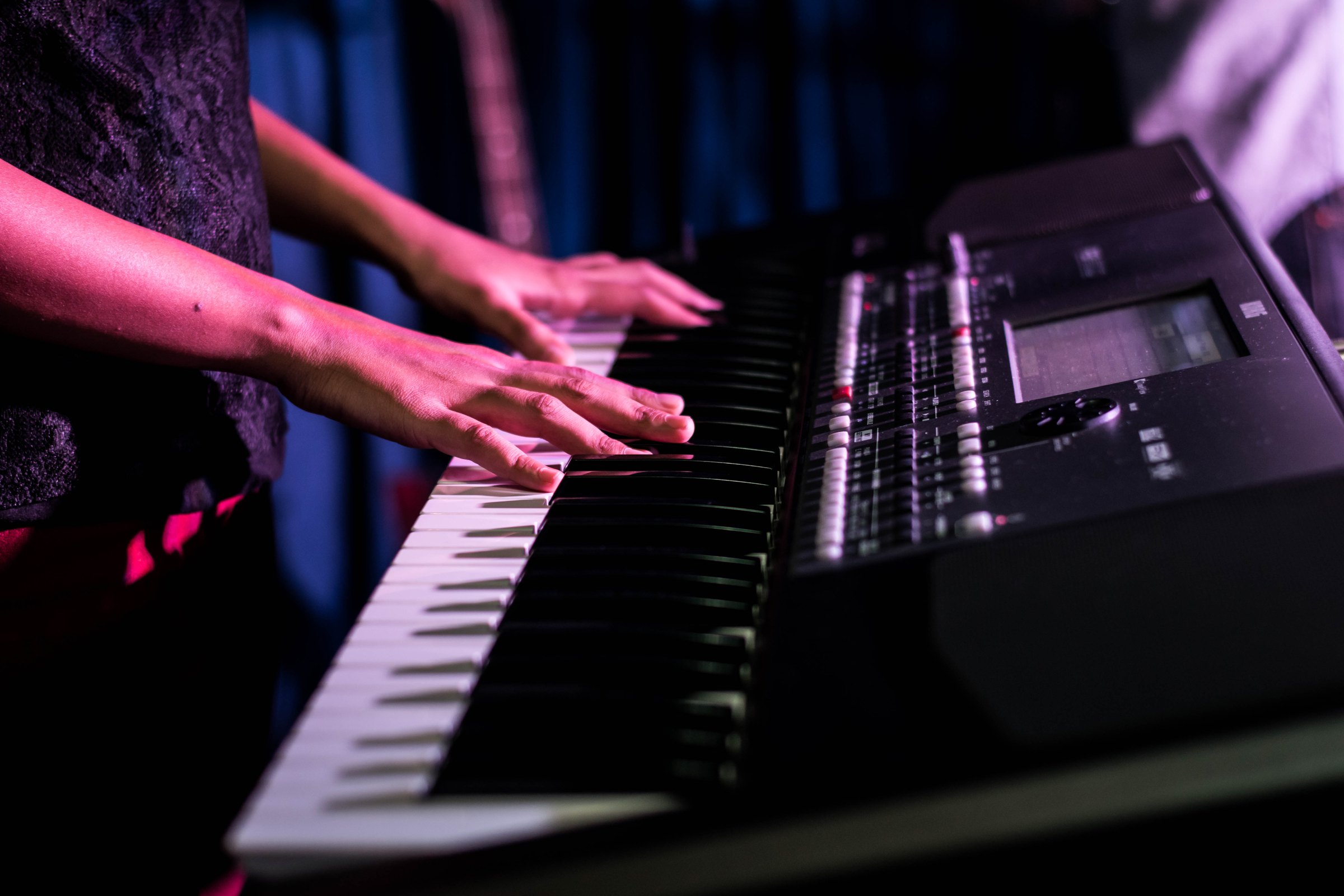 Hands on the keyboard under stage lights