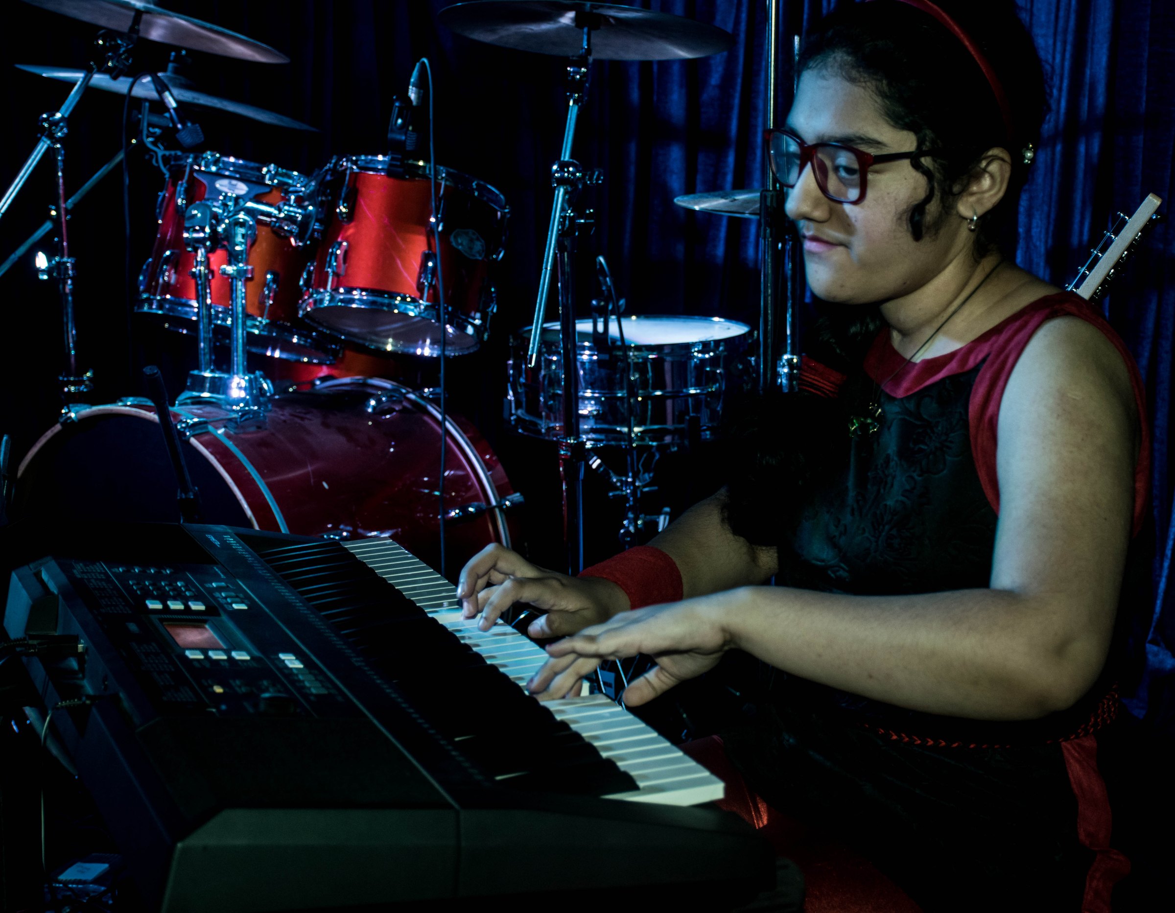 Pianist performing at a keyboard on stage