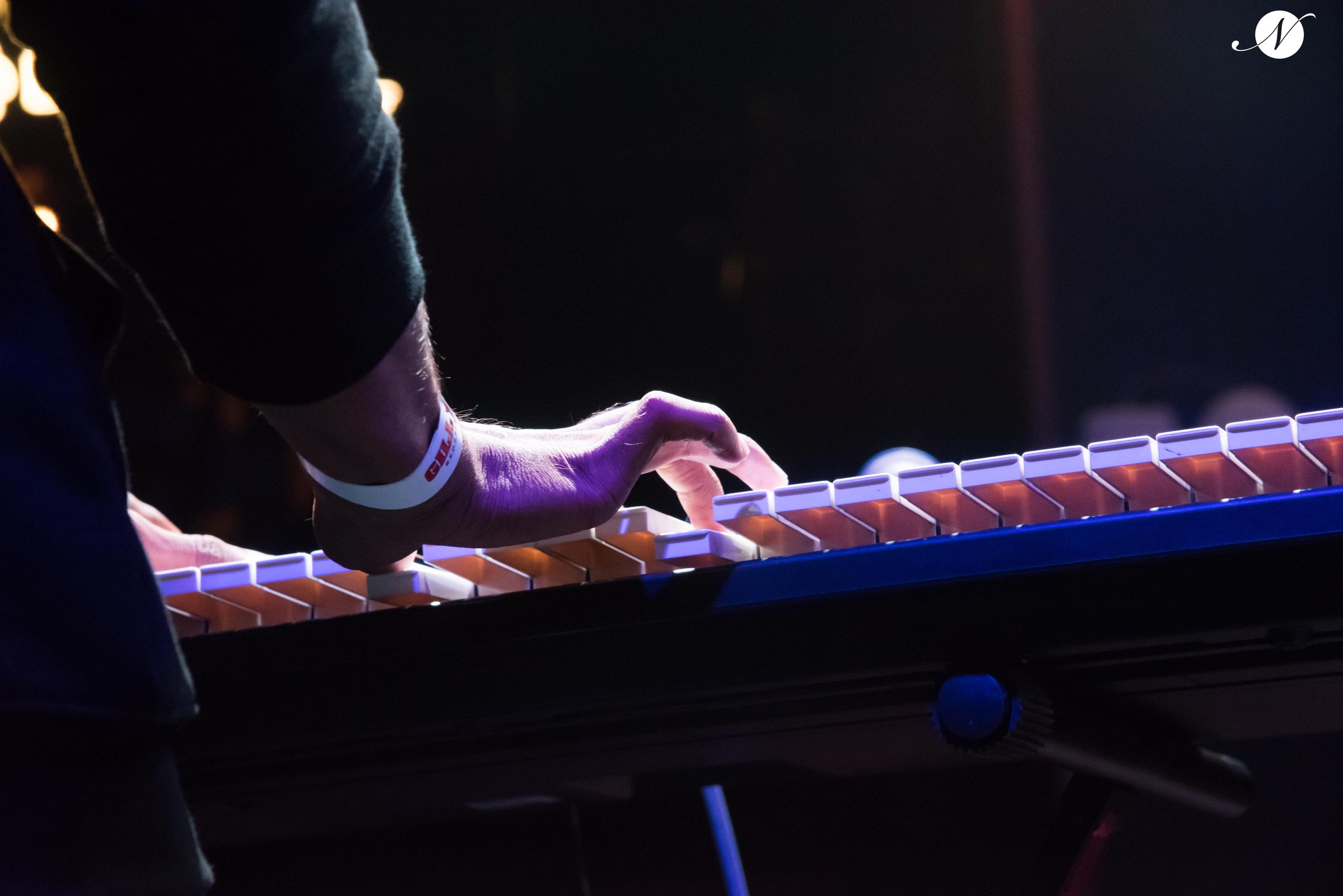 Hand reaching across illuminated keys