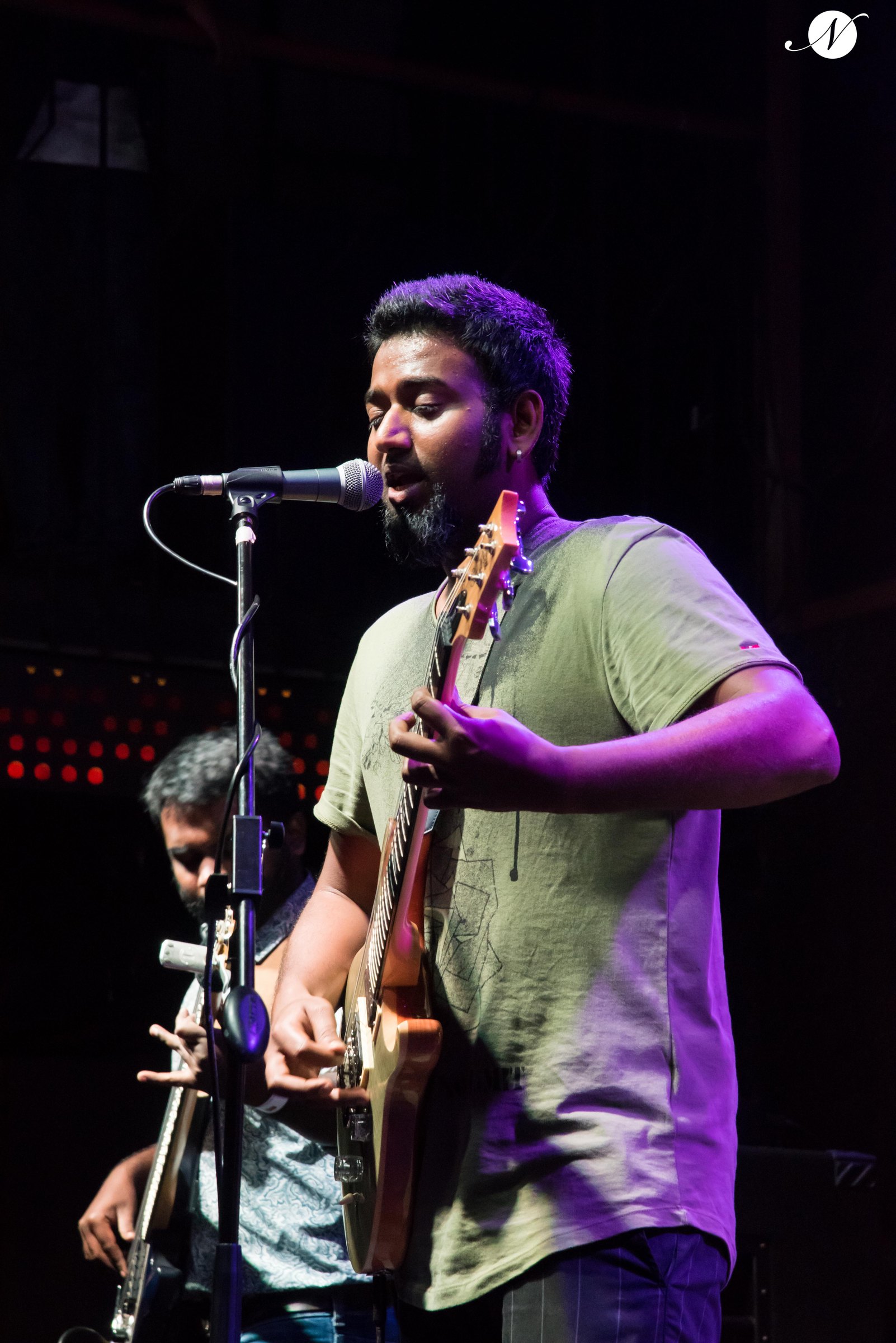 Bearded guitarist singing into mic
