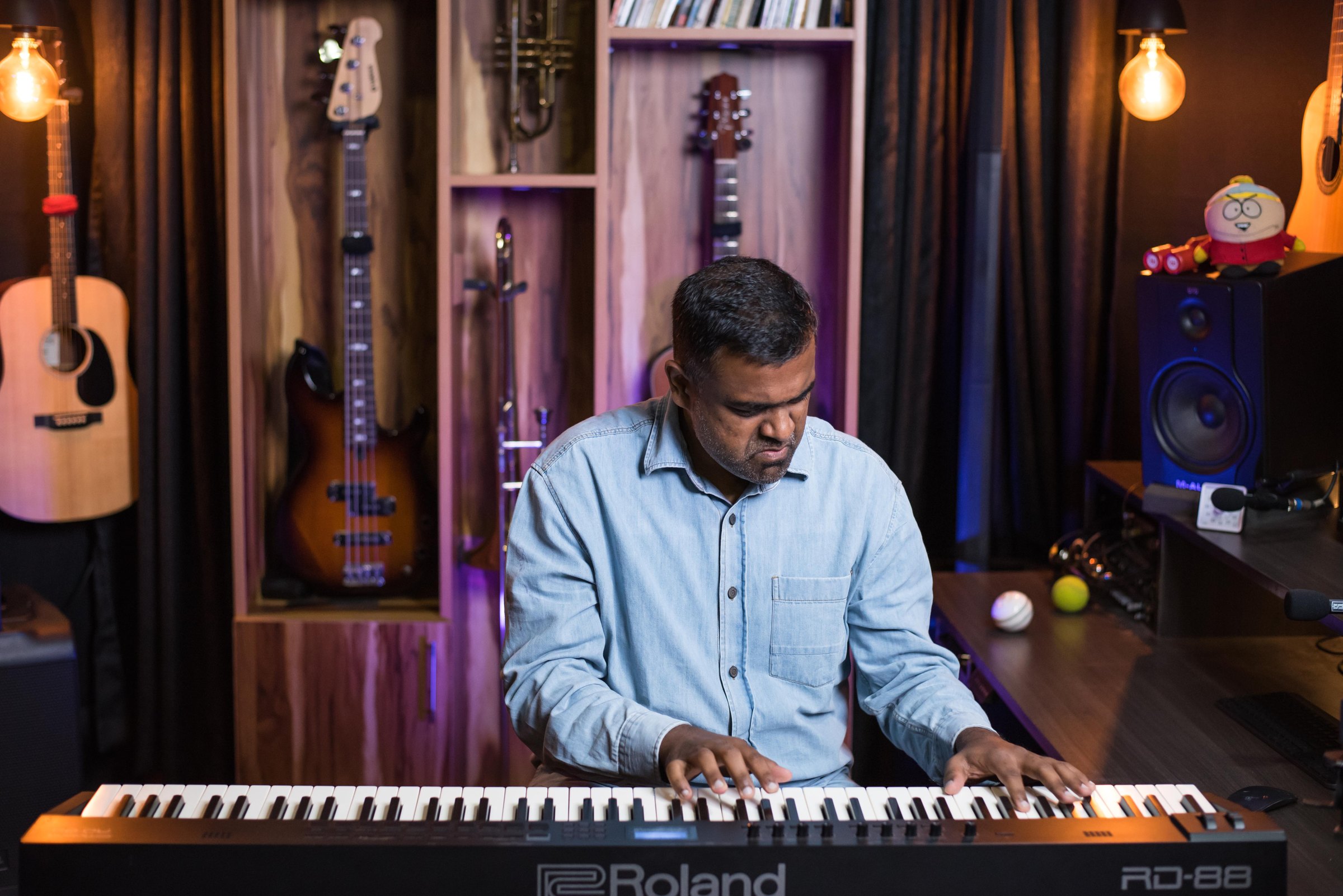 Jason at piano in studio, blue shirt