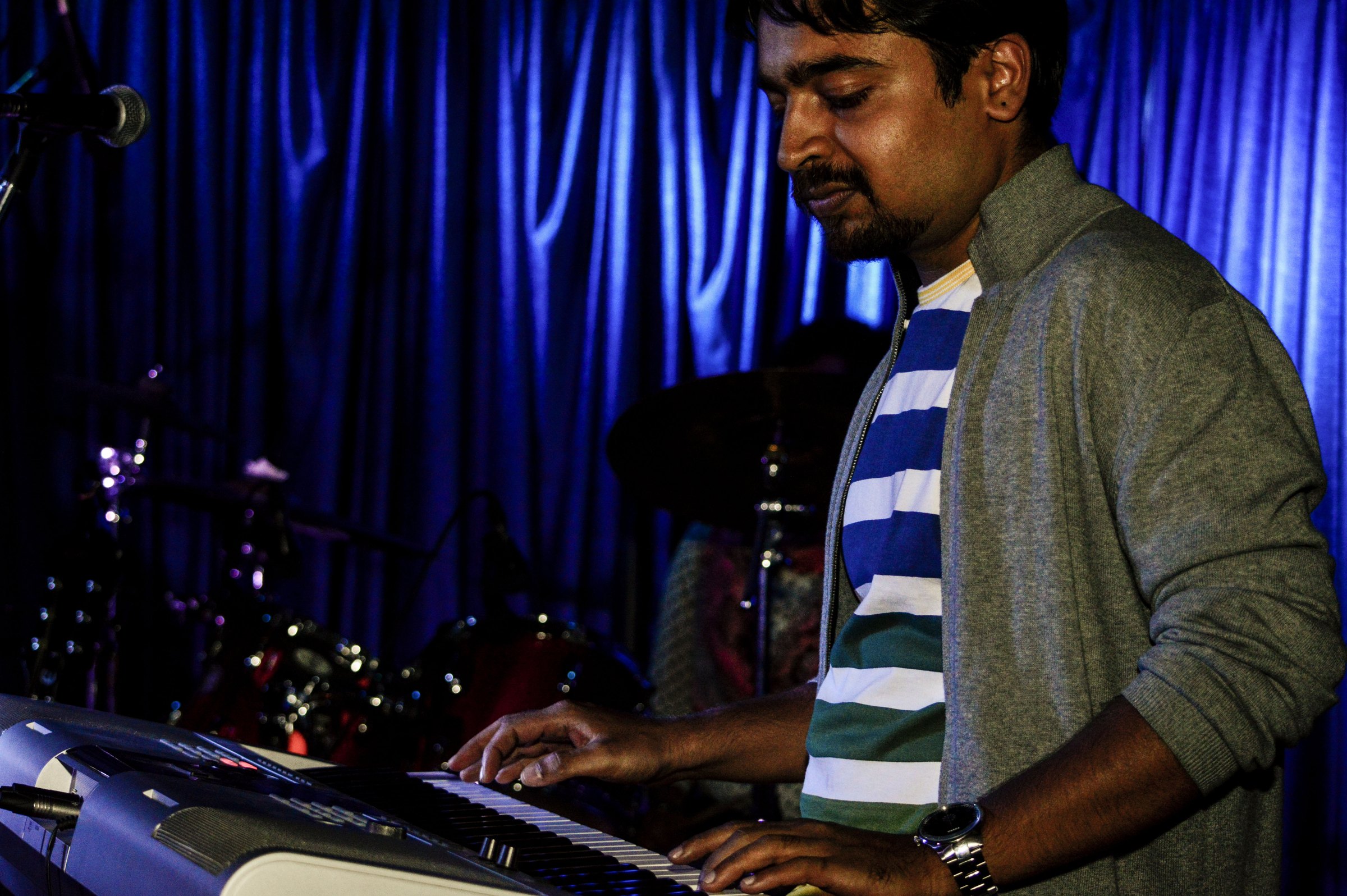 Pianist with striped tee at the keyboard