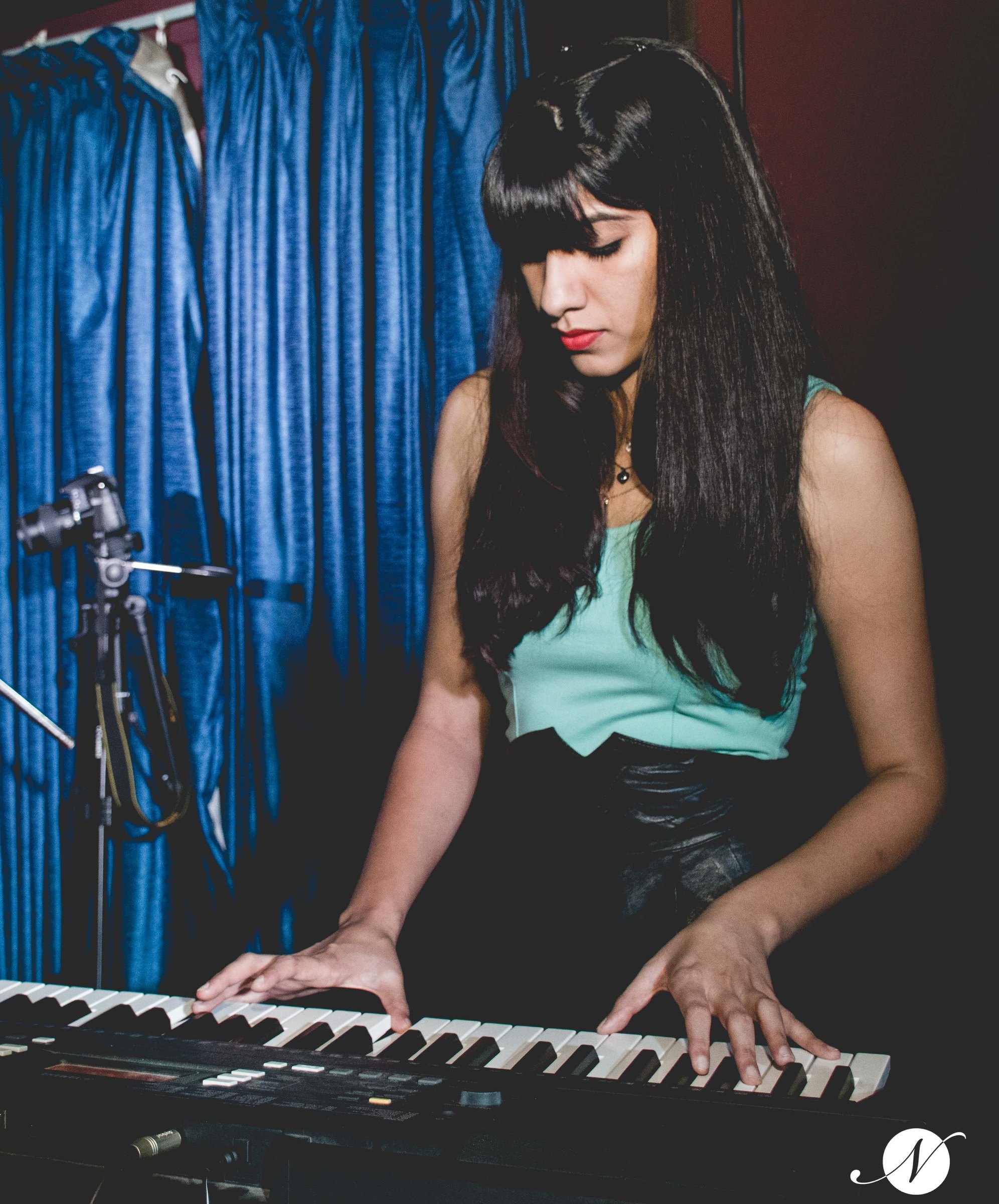 Pianist seated at a keyboard on stage